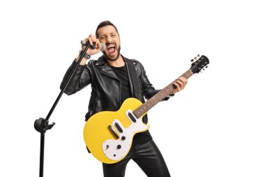 Mikrofonlu ve elektro gitarlı bir erkek şarkıcı beyaz arka planda yüksek sesle şarkı söylüyor. 
