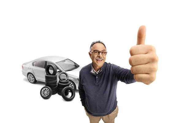 Mature Man Showing Thumb Front Car Pile Tires Isolated White — Stock Photo, Image