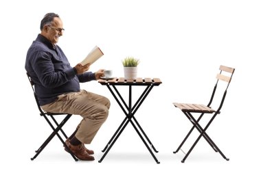 Beyaz arka planda izole edilmiş bir kafede kitap okuyan yaşlı bir adamın profil fotoğrafı.