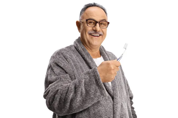 Starší Muž Županu Drží Zubní Kartáček Izolované Bílém Pozadí — Stock fotografie