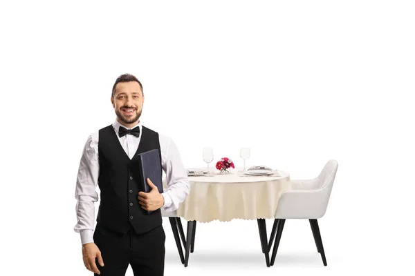 服务员打着领结 在被白色背景隔开的餐桌前摆着菜单 — 图库照片