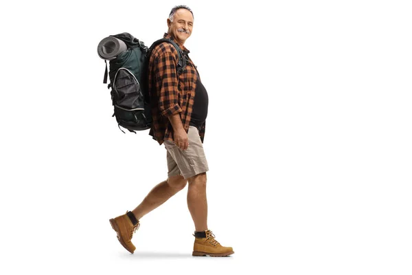 一个背负式背包步行的成熟远足者在白色背景下的全长侧面照片 — 图库照片