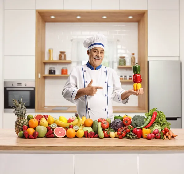 Mature Male Chef Kitchen Pile Fruits Vegetables Peppers His Hand — Stock Photo, Image