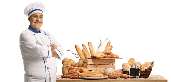 白を基調としたパンが異なるテーブルの前に立つ熟女シェフのパン屋 — ストック写真