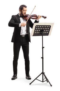 Erkek kemancı, beyaz arka planda izole edilmiş bir müzik tezgahının önünde keman çalıyor. 