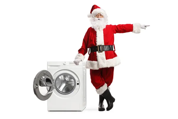 Full Length Portrait Santa Claus Leaning Washing Machine Pointing Side — Stock Photo, Image