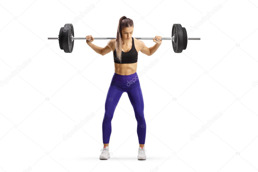 Full length portrait of a female bodybuilder exercising weight lifting isolated on white background