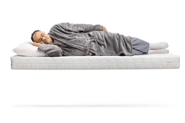 一个成熟的男人睡在一个床垫上 在白色背景上孤身一人飘浮 — 图库照片