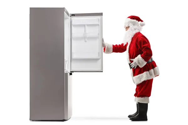 Ganzseitige Profilaufnahme Eines Weihnachtsmannes Der Vor Einem Leeren Kühlschrank Steht — Stockfoto