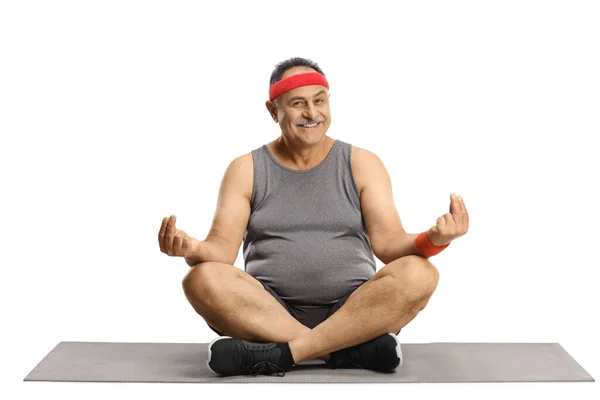 Glimlachende Volwassen Man Zittend Een Trainingsmat Beoefenend Yoga Meditatie Geïsoleerd — Stockfoto