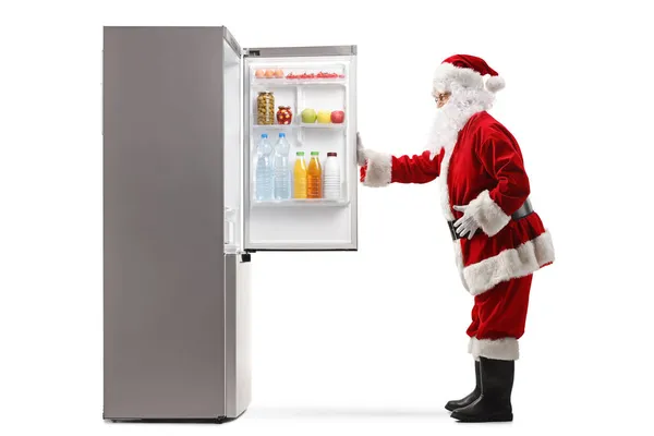 Ganzseitige Profilaufnahme Eines Weihnachtsmannes Der Vor Einem Kühlschrank Steht Mit — Stockfoto