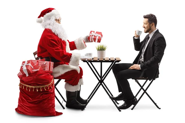 Święty Mikołaj Siedzi Przy Stole Daje Prezent Świąteczny Biznesmenowi Kupą — Zdjęcie stockowe