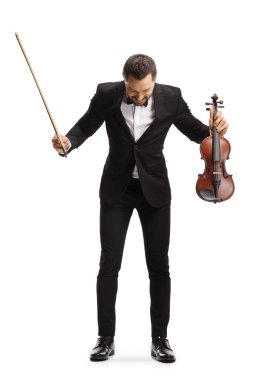 Beyaz arka planda izole edilmiş performanstan sonra eğilen bir kemancının tam boy portresi 