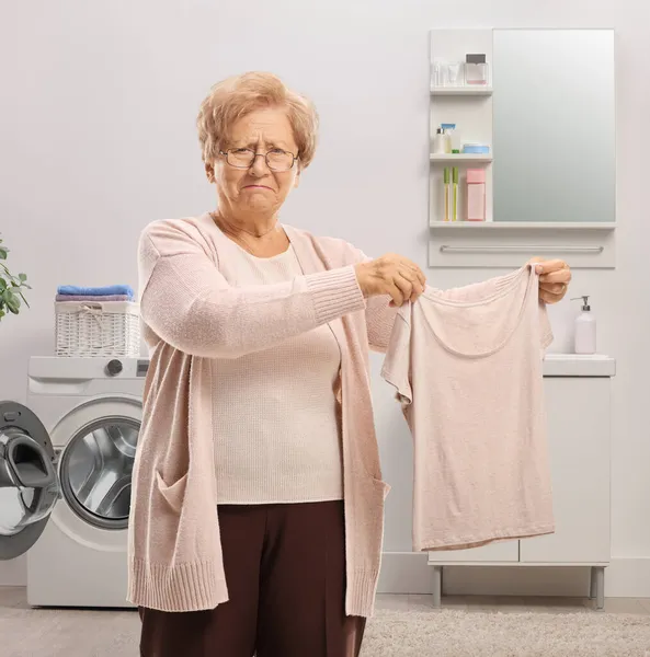 Grumpy Oudere Vrouw Met Een Gekrompen Shirt Een Badkamer — Stockfoto