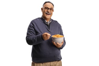 Gülümseyen olgun bir adam beyaz arka planda izole bir kase mısır gevreği tutuyor.