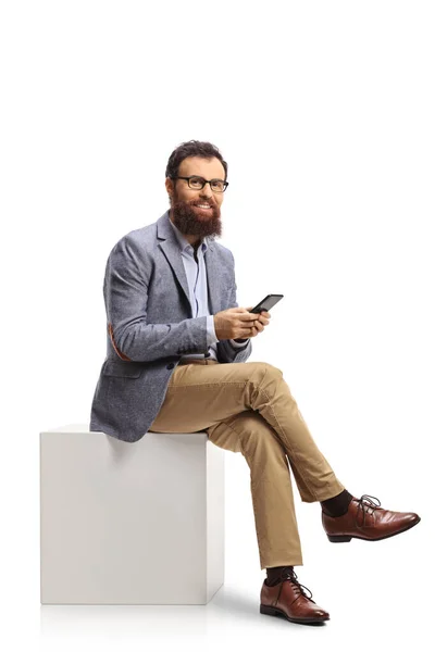 Homme Barbu Assis Sur Cube Blanc Tenant Smartphone Isolé Sur — Photo