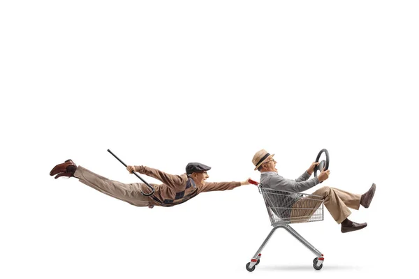 白い背景に隔離された中に男とショッピングカートを保持高齢者を飛んで — ストック写真