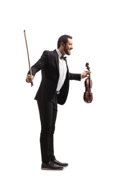 Gülümseyen erkek kemancı beyaz arka planda izole edilmiş bir performansın ardından eğiliyor 