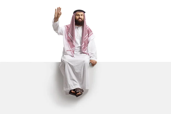 Saudita Árabe Homem Sentado Painel Branco Acenando Para Câmera Isolada — Fotografia de Stock