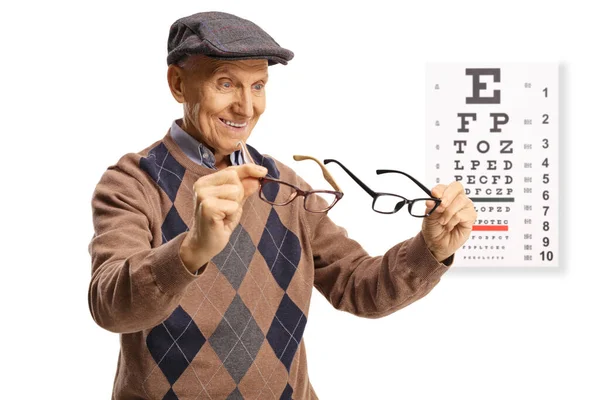 Äldre Man Håller Glasögon Framför Vision Examen Isolerad Vit Bakgrund — Stockfoto