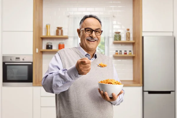 Усміхнений Зрілий Чоловік Стоїть Кухні Їсть Кукурудзяні Пластівці — стокове фото
