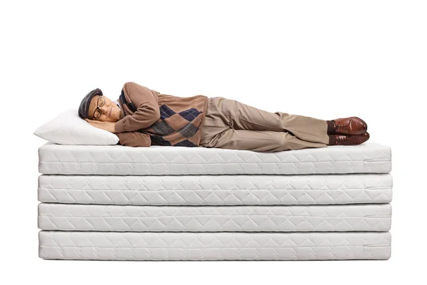 Älterer Mann Schläft Auf Einem Haufen Matratzen Isoliert Auf Weißem — Stockfoto