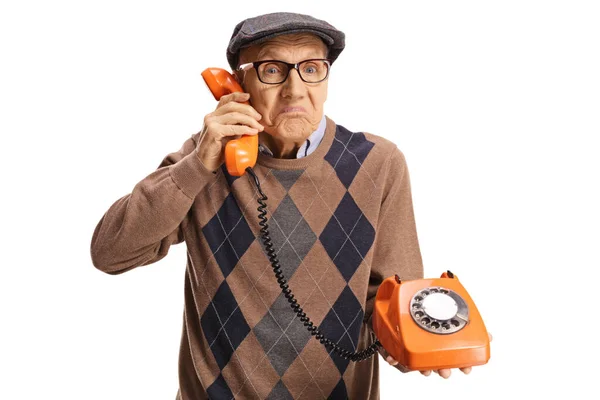 Hombre Mayor Confundido Sosteniendo Teléfono Giratorio Vintage Mirando Cámara Aislada — Foto de Stock