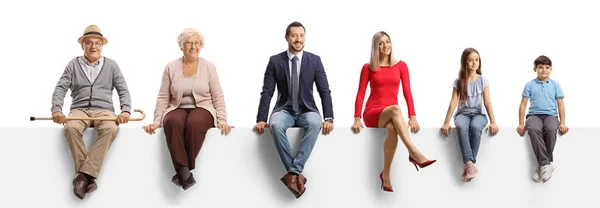 Una Familia Tres Generaciones Sentada Panel Blanco Sonriendo Cámara Aislada — Foto de Stock