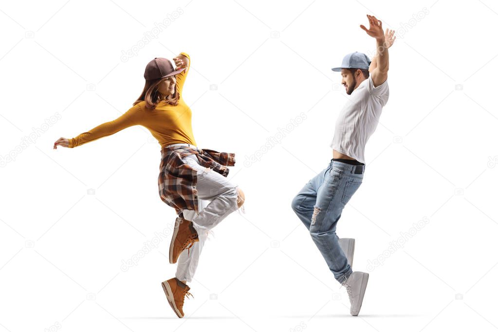 Full length profile shot of a guy and girl dancing hip hop isolated on white background