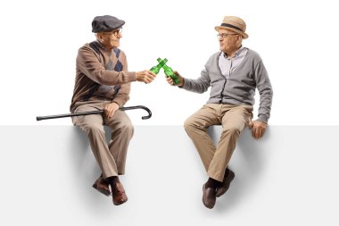 Yaşlı adamlar boş bir panelde oturup beyaz arka planda izole edilmiş bira şişeleriyle kadeh kaldırıyorlar.