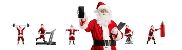 Święty Mikołaj Trzymający Smartfona Przed Innymi Klauzulami Mikołaja Ćwiczącymi Sprzętem — Zdjęcie stockowe