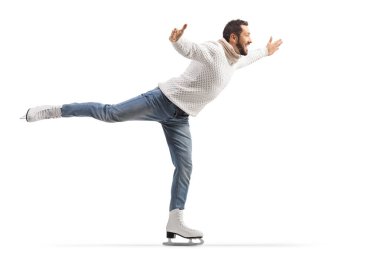 Kot pantolon ve beyaz örgü elbiseli bir adamın beyaz arka planda buz pateni yaparken tam boy profil fotoğrafı.