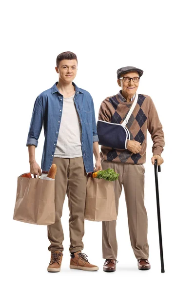 Joven Ayudando Anciano Con Brazo Roto Llevando Bolsas Compras Aisladas — Foto de Stock