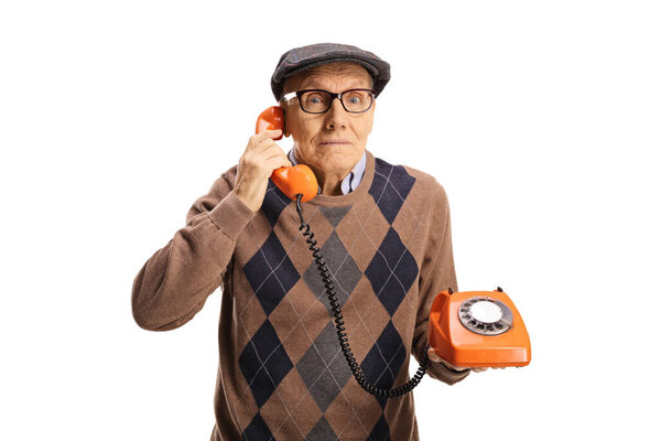 Elderly man making a phone call with an old vintage rotary phone isolated on white background
