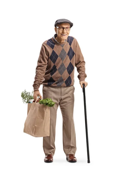一个拿着手杖 提着用白色背景隔开的购物袋的老人的全长肖像 — 图库照片