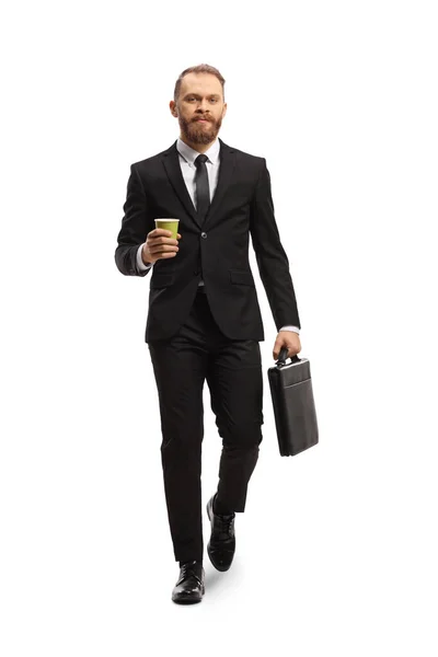 若い実業家が歩くと 白い背景に隔離されたブリーフケースとテイクアウトコーヒーカップを保持の完全な長さの肖像画 — ストック写真