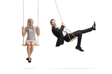İş adamı ve genç bir kadın beyaz arka planda izole edilmiş salıncaklarda oturuyorlar.