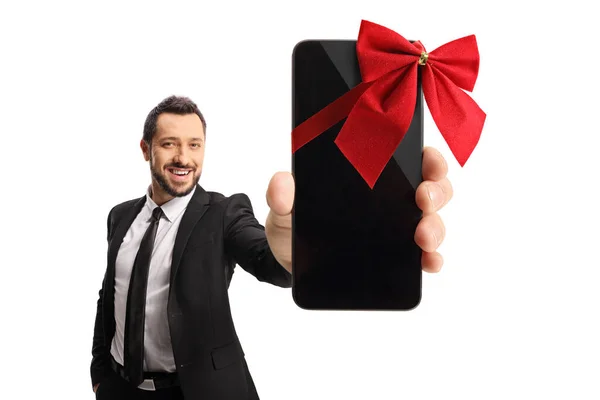 白地に隔離されたカメラの前に赤い蝶ネクタイのスマートフォンを持っているビジネスマン — ストック写真