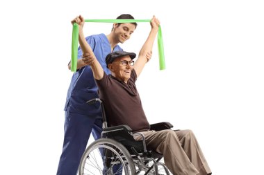 Physical therapist helping an elderly man in a wheelchair exercising with a stretch band isolated on white background