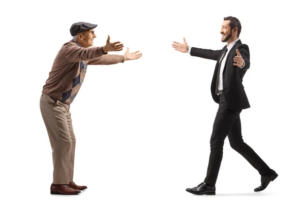 白人の背景に隔絶された腕で互いに向かって歩いている老人と若い実業家の完全な長さのプロフィール — ストック写真