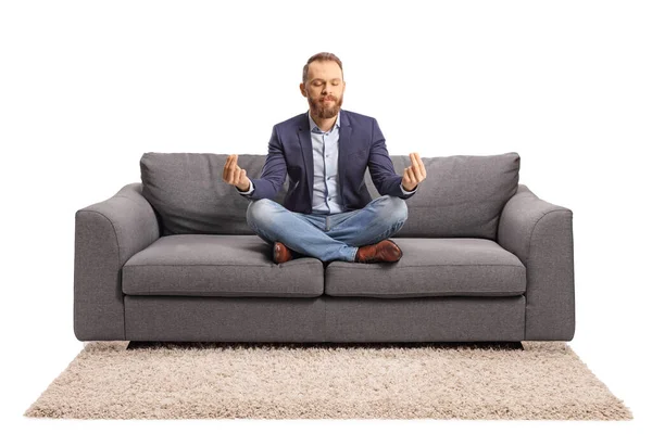 Young Man Casual Elegant Clothes Meditating Sofa Isolated White Background — Φωτογραφία Αρχείου