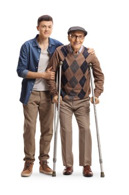 Young man helping an elderly man walking with crutches isolated on white background