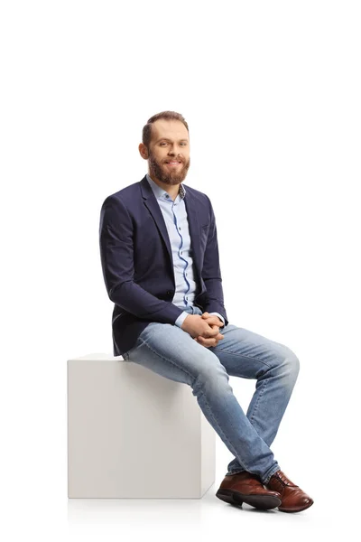 Young Professional Man Sitting White Cube Smiling Isolated White Background — Stockfoto