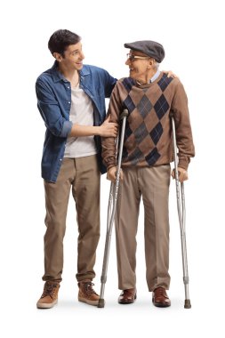 Elderly man with crutches and a young man standing and looking at each other isolated on white background