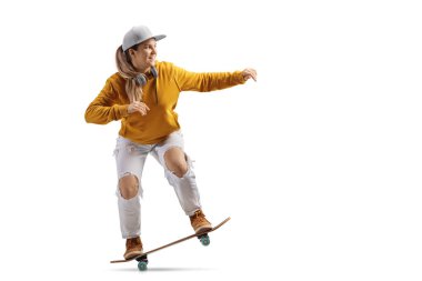 Trendy female with headphones around neck riding a skateboard isolated on white background