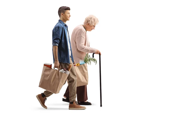 Full Length Profile Shot Elderly Woman Walking Cane Young Man — Stok fotoğraf