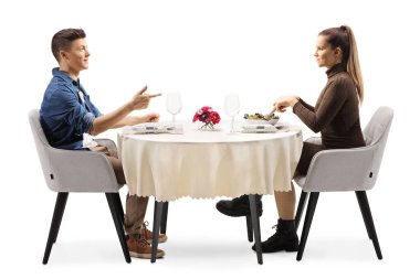 Sıradan bir genç adam ve kadının, restoran masasında otururken ve beyaz arka planda izole bir şekilde konuşurken profil fotoğrafı.