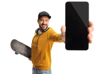 Beyaz arka planda izole edilmiş akıllı telefon tutan kaykaylı sarı kazaklı bir adam.