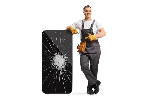 Full Length Portrait Repairman Leaning Smartphone Cracked Screen Pointing Isolated — Stock Photo, Image
