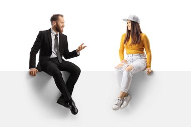 Bir panelde oturan iş adamı beyaz arka planda izole edilmiş genç ve modaya uygun bir kadınla konuşuyor.